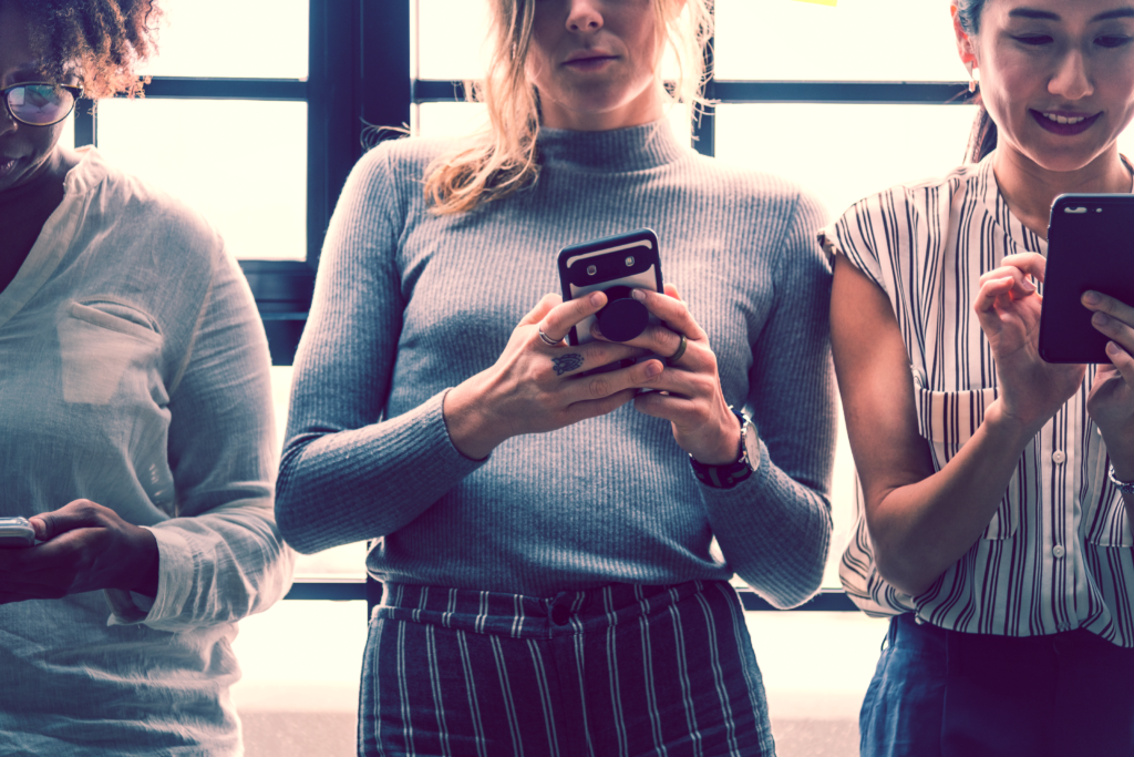 Three women looking at smartphones