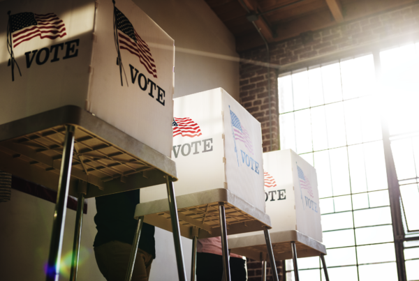 Voting booths in a room with sun shining in